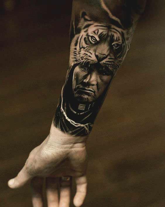 Tiger with men face tattoo on inner forearm