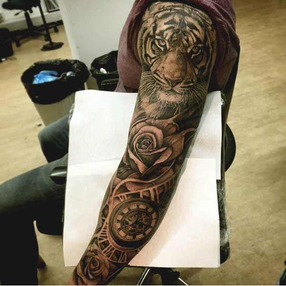 Tiger tattoo on full arm with rose and compass designs for guys