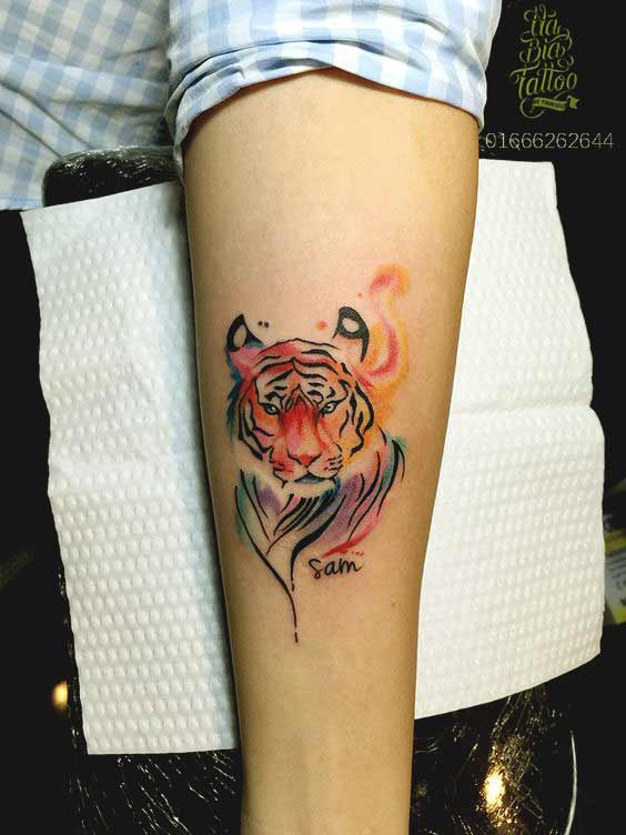 Small watercolor tiger face tattoo on inner arm