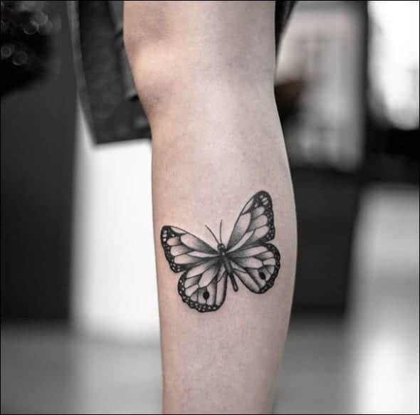 Black butterfly tattoo design on leg