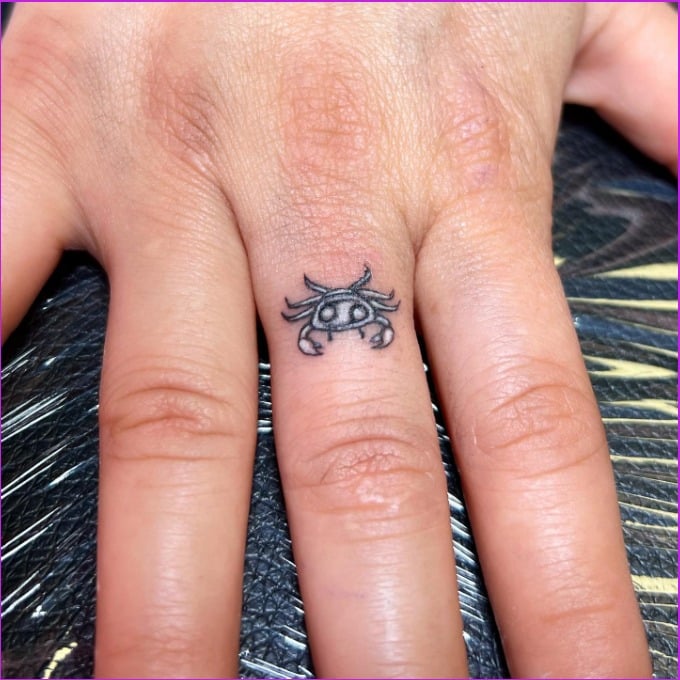 small cancer zodiac tattoo on finger