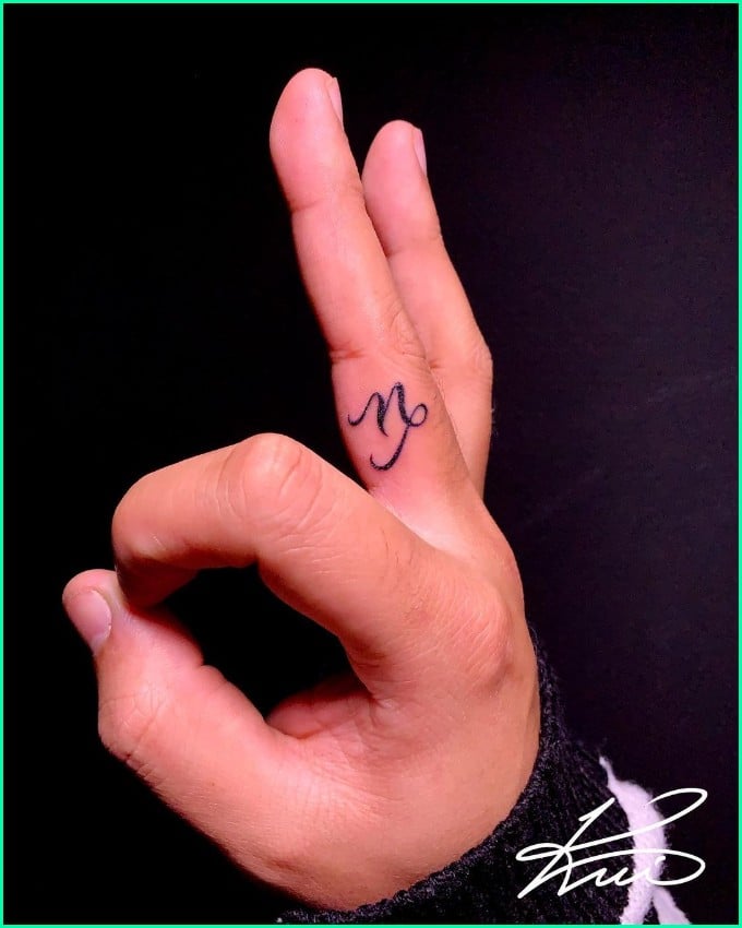 small capricorn tattoo on finger