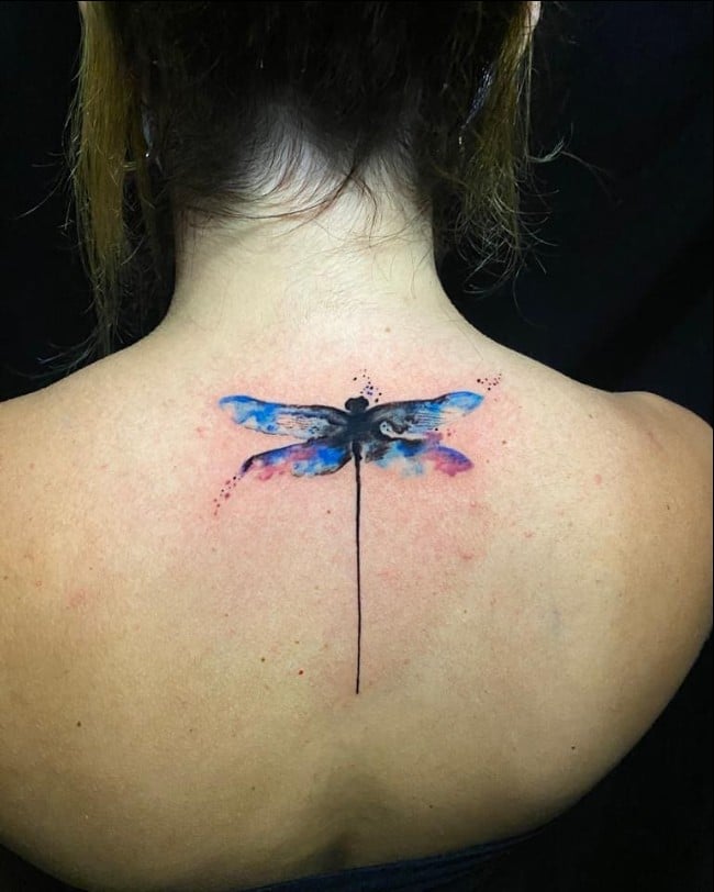 Colorful dragonfly tattoo located on the inner forearm