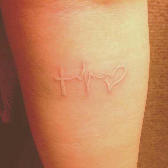 White ink faith hope and love tattoo symbols seems that they are present inside the skin