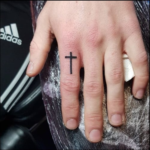 small cross on finger tattoo