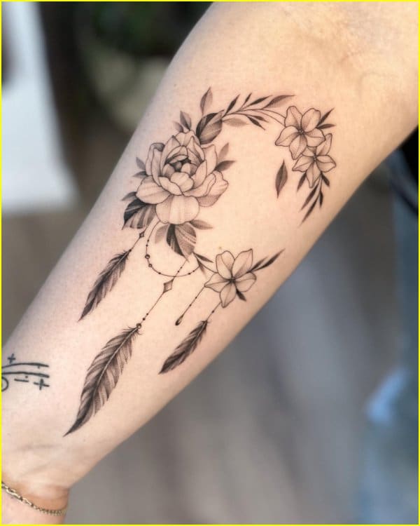 rose tattoos with feather on wrist