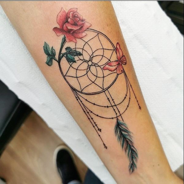 Large rose and feather tattoo located on the forearm