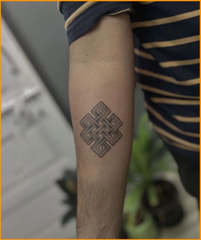 endless knot spiritual tattoo on forearms