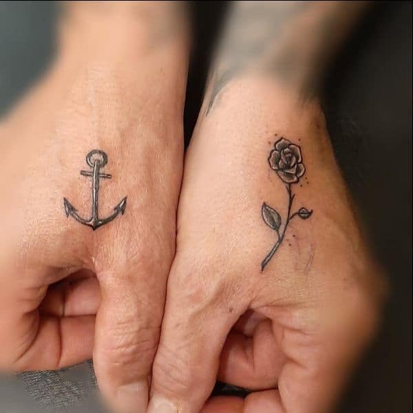 rose and anchor tattoos on hand 